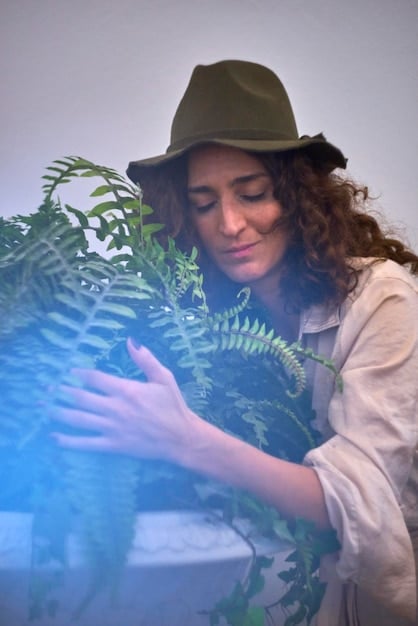 A detailed shot of a researcher examining restored plant life in a previously degraded habitat, highlighting the scientific approach to habitat restoration and the importance of monitoring project outcomes.