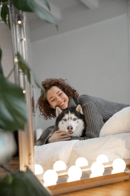 A dog cheerfully playing fetch with its owner in a brightly lit room, showcasing the positive impact of increased light exposure on the dog's mood and activity level.